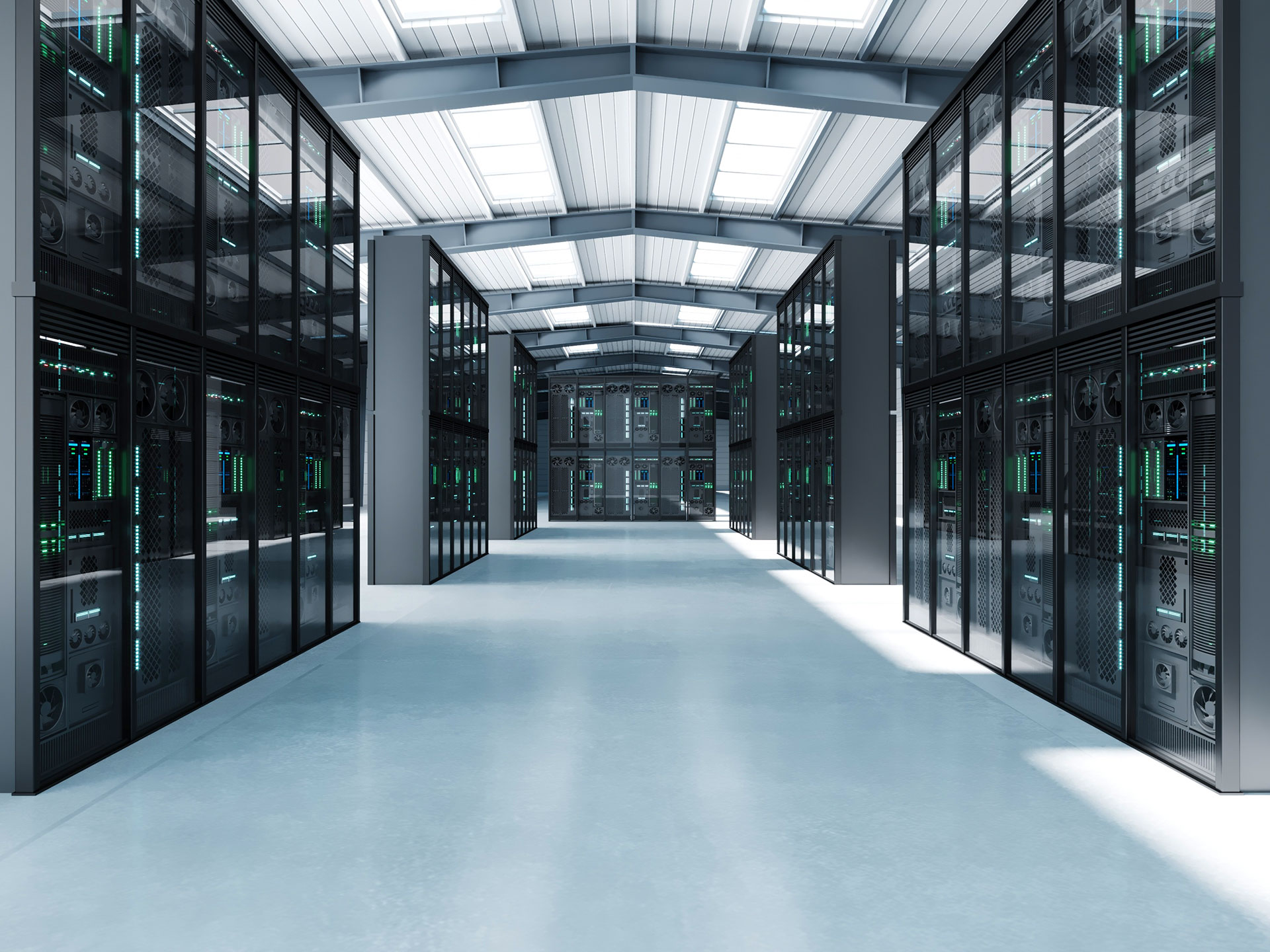 Large enterprise data center with rows of black server racks under a vaulted ceiling